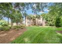 Expansive backyard with lush lawn, mature trees, and a stone patio perfect for outdoor gatherings at 174 Hickory Hill Rd, Mooresville, NC 28117