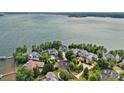 Aerial view of luxury waterfront homes and manicured lawns with a large body of water in the background at 18007 Harbor Light Blvd, Cornelius, NC 28031