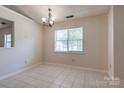 Bright dining room with tiled floors and a modern chandelier fixture at 1801 Teddington Dr, Charlotte, NC 28214