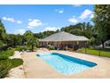 Backyard oasis featuring a sparkling pool, mature trees, and black aluminum fence at 1958 Cameron Heights Cir, Denver, NC 28037