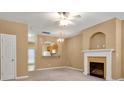 Cozy living room featuring fireplace, modern ceiling fan and open archway to the kitchen at 212 Township Dr, Fort Mill, SC 29715