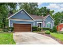 Beautiful home with blue siding, a brown garage door, and a lovely landscaped front yard at 2133 Highland View Ln, Charlotte, NC 28214