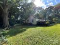 A quaint home surrounded by lush greenery, featuring well-maintained grounds and mature trees at 2411 Rebecca Ave, Charlotte, NC 28208