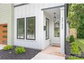 Inviting entrance showcasing a modern white door, black accents, and manicured landscaping at 2733 Cowles Rd, Charlotte, NC 28208