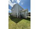 Fenced backyard showcasing green grass, the home's gray siding, and space for outdoor activities and leisure at 2810 Shumard Dr, Gastonia, NC 28054