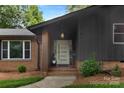 Inviting front entrance with a modern door, brick accents, manicured landscaping, and a hanging light fixture at 3701 Table Rock Rd, Charlotte, NC 28226