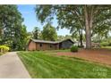 Beautifully landscaped front yard with a large tree shading the charming brick and siding home at 3701 Table Rock Rd, Charlotte, NC 28226