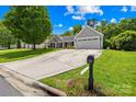 Attractive one-story home featuring a meticulously maintained lawn and an extended driveway leading to an attached two-car garage at 4313 Wynborough Ln, Charlotte, NC 28269