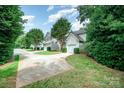 Charming home featuring a well-manicured lawn and a tree-lined yard with a one-car garage at 4703 David Cox Rd, Charlotte, NC 28269