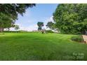 Spacious backyard offering a play set and a large grassy area perfect for outdoor activities and recreation at 5445 Creekwood Dr, Salisbury, NC 28147