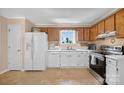 Functional kitchen featuring white appliances, ample cabinetry, and natural light from a window above the sink at 5445 Creekwood Dr, Salisbury, NC 28147