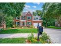Beautiful brick home with green shutters, green front door, and a well-manicured, landscaped lawn at 6016 Graburns Ford Dr, Charlotte, NC 28269
