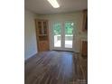 Open dining area with hardwood floors, a built-in hutch, and a door leading to the deck at 608 Sharon Dr, Statesville, NC 28625
