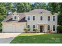 Charming traditional home with a two-car garage, manicured lawn, and covered front entrance at 7151 Plough Dr, Mint Hill, NC 28227