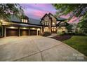 Beautiful exterior of a home featuring a stone facade, three-car garage, and well-maintained landscaping at 8016 Pemswood St, Charlotte, NC 28277