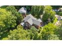 A high angle, full view of a brick home with mature trees, deck, and lush landscaping at 8900 Cumbria Ct, Huntersville, NC 28078