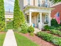 Charming home exterior featuring a covered porch, landscaped yard, and an American flag display at 9730 White Frost Rd, Charlotte, NC 28277