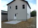 Exterior view of the home's rear showcasing the back door and a small patio area at 258 Lincoln Sw St, Concord, NC 28025