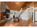 Cozy living room boasts a stone fireplace, wood ceiling, and staircase to the upper level at 360 Lake Landing Dr, Salisbury, NC 28146