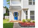 Close-up of the home's front entrance, showcasing a vibrant blue door, white trim, and a neatly landscaped walkway at 411 Carlisle Dr, Indian Trail, NC 28079