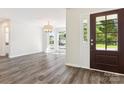 Bright and airy living room with hardwood floors and a modern chandelier, illuminated by natural light from the windows at 411 Carlisle Dr, Indian Trail, NC 28079