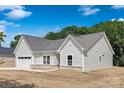 Side angle of a well-maintained single-story home with a two-car garage and gray roof at 4472 Pebblebrook Sw Cir, Concord, NC 28027