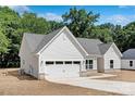 Side angle of a well-maintained single-story home with a two-car garage and gray roof at 4472 Pebblebrook Sw Cir, Concord, NC 28027