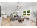 Bright living room with vaulted ceiling, hardwood floors, large window, and modern furnishings at 4472 Pebblebrook Sw Cir, Concord, NC 28027