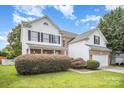 Two-story home featuring vinyl siding, black shutters, brick accents, manicured landscaping and a two-car garage at 4835 Chesney Nw St, Concord, NC 28027