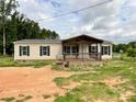 Inviting home features a quaint front porch and neutral siding complementing the dark shutters at 5321 State Line Rd, Marshville, NC 28103