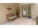 Inviting covered front porch featuring a bench, shelves, and a decorative wreath on the door at 7164 Moss Point Dr, Charlotte, NC 28277