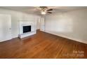 Bright living room with fireplace, ceiling fan, and beautiful hardwood floors at 7812 Old Concord Rd, Salisbury, NC 28146