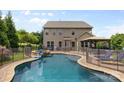 Back of house showing an in-ground pool, hot tub, and fenced yard, with ample space for recreation and relaxation at 9801 Blackbird Hill Ln, Mint Hill, NC 28227