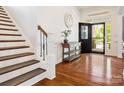 Elegant foyer with hardwood floors, staircase, decorative table, and a view of the front door at 1009 Hampton Grove Rd, Waxhaw, NC 28173