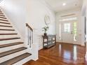 Bright foyer with hardwood floors, a staircase, decorative table, and a glass-paneled front door at 1009 Hampton Grove Rd, Waxhaw, NC 28173