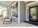 Inviting front porch with comfortable seating, stylish shutters, and a black front door at 1009 Hampton Grove Rd, Waxhaw, NC 28173