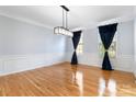 Bright, spacious dining room with hardwood floors, wainscoting, and modern light fixture at 1009 Murandy Ln, Matthews, NC 28104