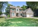 Charming two-story home featuring brick and siding, large bay windows, and a manicured front lawn at 1045 Fairway Ridge Nw Rd, Concord, NC 28027