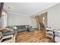 Open-concept living room featuring hardwood floors, a staircase, a comfortable sectional sofa, and natural light at 1045 Fairway Ridge Nw Rd, Concord, NC 28027