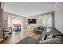 Bright and spacious living room with hardwood floors, a large sectional sofa, and a large bay window at 1045 Fairway Ridge Nw Rd, Concord, NC 28027