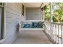 Relax on this charming front porch swing with decorative pillows and painted wood railing at 110 Club Dr, Mooresville, NC 28115