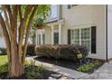 Inviting front entrance with black door, decorative shrubbery, and meticulous landscaping at 129 Nims Spring Dr, Fort Mill, SC 29715
