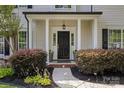 Welcoming front porch featuring classic columns, manicured bushes and a black door at 129 Nims Spring Dr, Fort Mill, SC 29715