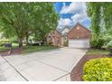 A charming brick home featuring a long driveway leading to an attached two-car garage at 14103 Hiawatha Ct, Huntersville, NC 28078