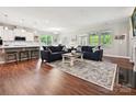 Open-concept living room with hardwood floors, a fireplace, and ample natural light at 15614 Aviary Orchard Way, Charlotte, NC 28278
