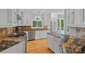 Open-concept kitchen featuring granite countertops, stainless appliances, and warm wood floors at 15724 Eagleview Dr, Charlotte, NC 28278