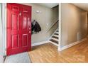 Inviting foyer with a bright red door, hardwood floors, and a staircase leading to the upper level at 2040 Brantley Creek Dr, Kannapolis, NC 28083