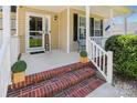 Close-up of a welcoming front porch with brick steps, potted plants, and a 'welcome' sign at 2040 Brantley Creek Dr, Kannapolis, NC 28083
