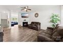 Inviting living room featuring a fireplace, ceiling fan, hardwood floors, and comfortable seating at 3734 Stanley Creek Dr, Mount Holly, NC 28120