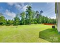 Expansive green backyard with lush grass and partial fence, perfect for outdoor activities and relaxation at 3855 Tersk Dr, Midland, NC 28107